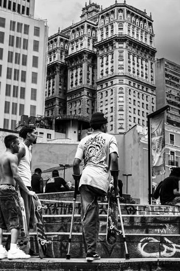 Homens em uma escadaria com prédios históricos do centro ao fundo
